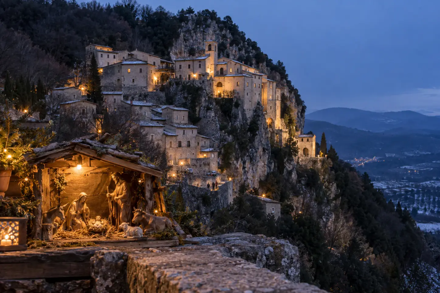 Il borgo di Greccio sulla roccia con il santuario francescano al tramonto, e un piccolo presepe di legno in primo piano